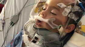 Blake Collie in the hospital after a blood vessel burst in his brain. His care was covered by Medicaid, but his family has a health-sharing plan under Samaritan Ministries, a faith-based organization. 