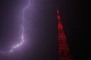 Lightning lights up the sky behind a television tower as a thunderstorm moves through the area Thursday, April 23, 2026, in Kansas City, Missouri.