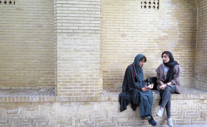 Shaghayagheh Aghazadeh, left, and Atikeh Karimi enjoy some quiet moments at the tomb of Hafez, where they seek clues to the future through the poet's words.