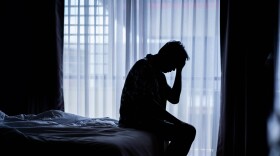 Depressed man sitting on a bed