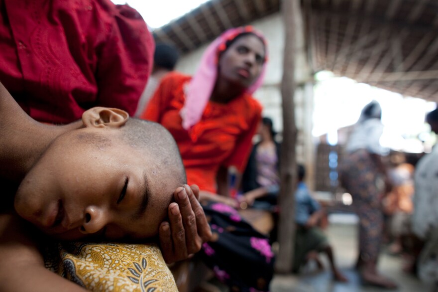 A mother holds her ailing son at a special clinic for malaria in Myanmar.