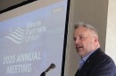 U.S. Rep. Eric Sorensen speaks into a microphone in front of a slideshow screen at the Illinois Farmers Union 2025 Annual Meeting on Tuesday in East Peoria.  