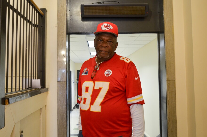 A man in a red jersey poses for a photo.
