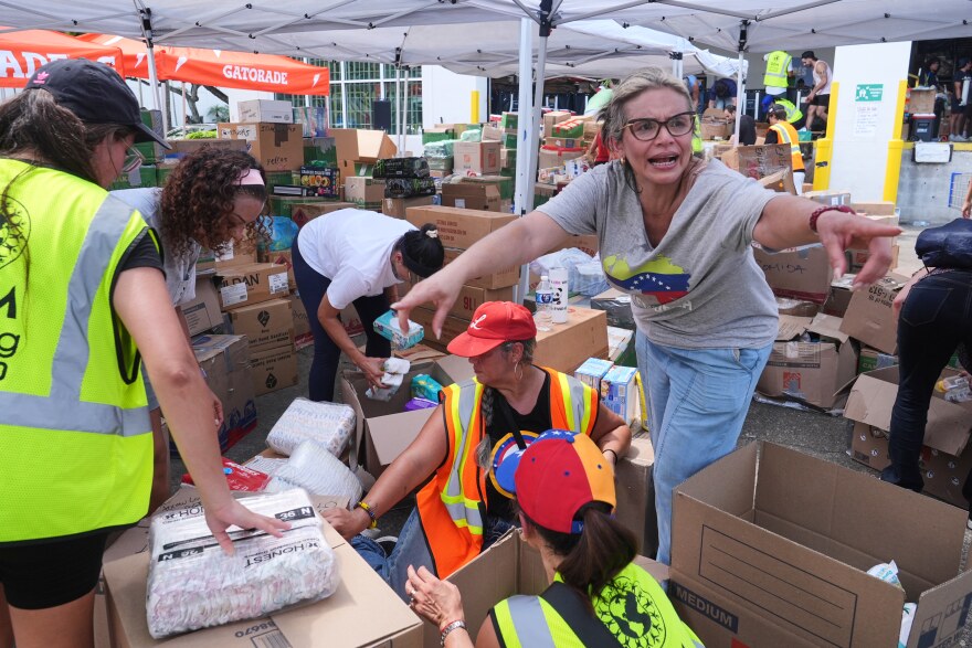 Lisa Galindez calls on other volunteers to help pack baby items at the Global Empowerment Mission Venezuela relief donation site Tuesday, June 30, 2026, in Doral, Fla.