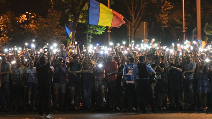 People wave Romanian national flags during a demonstration against the government on Saturday, during the second day of protests.