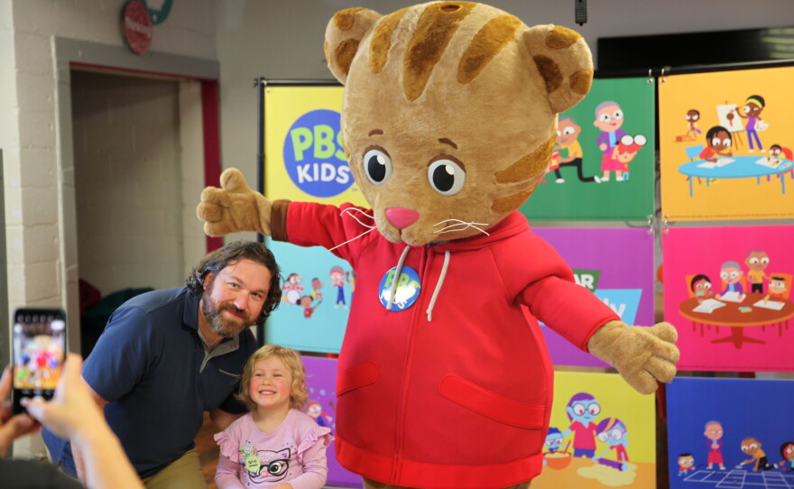 Visitors pose with Daniel Tiger at Be My Neighbor Day with WKAR.