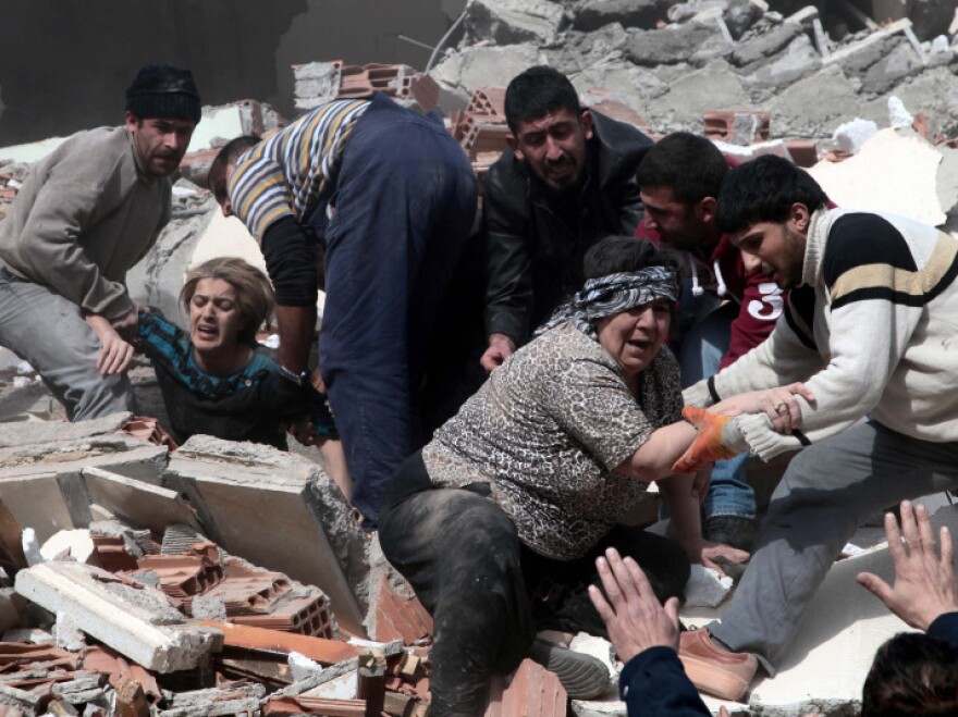 <p>People rescue two women who were trapped under debris after a powerful 7.2-magnitude earthquake in Van, eastern Turkey, on Sunday.</p>