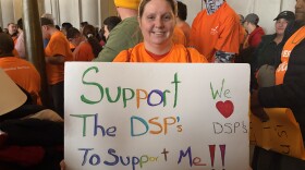 A disability advocate at the rally holds up a sign about supporting DSPs. (Direct Supprot Professionals) 