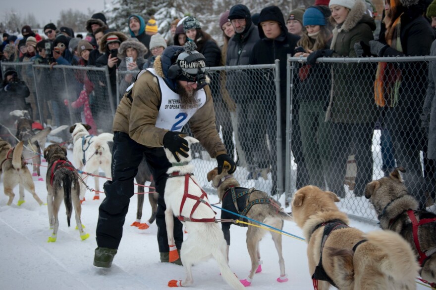 Keaton Loebrich pets his dogs before starting the 2026 Yukon Quest Alaska 750.