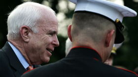Arizona Senator John McCain is escorted to his seat during the weekly Marine Corps Sunset parade at the Marine Corps War Memorial Aug. 3, 2009.