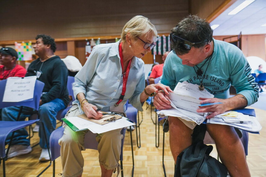 Sara Kennedy helps Bryan Pennington review his utility bill paperwork at All Saints' Episcopal Church Loaves & Fishes Ministry on Tuesday, August 18, 2026 in Austin, Texas. Pennington is recovering from spinal surgery and is unable to work. The ministry used an Austin Energy grant to cover his $287 electricity bill.