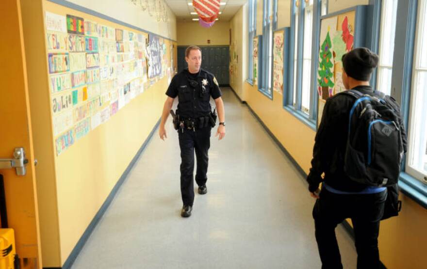 FILE - In this Dec. 17, 2012 photo, Officer Rick Moore of the Oakland school district police patrols Oakland Technical High School in Oakland, Calif.