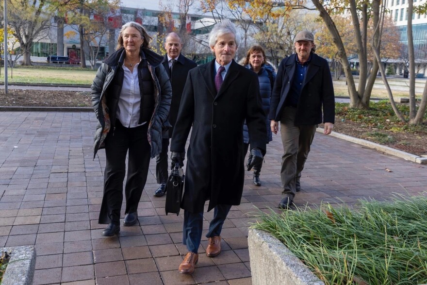 From left to right, Tami Graham, Stewart Vanderwilt, Steve Zansberg, Breeze Richardson, and Mike May walk into the E. Barrett Prettyman U.S. Court House in Washington, D.C. on Dec. 4, 2025. Graham, Vanderwilt, and Richardson lead three Colorado public radio stations suing the Trump administration alongside NPR over an executive order issued in May, 2025. In March 2026, a federal judge ruled in the plaintiffs' favor.