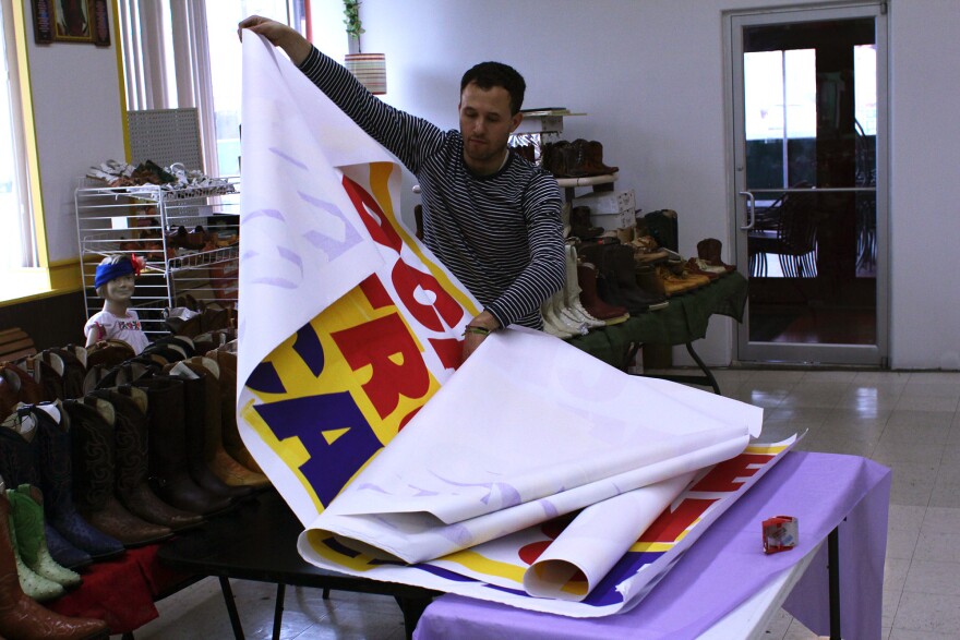 Artist Alberto Aguilar unrolls signs at El Torito grocey