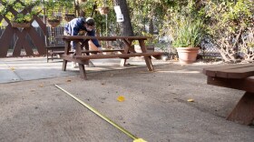 Zach Erickson adjusts tables to ensure they are socially distanced at Hop Garden Wednesday, Jan. 13, 2021.