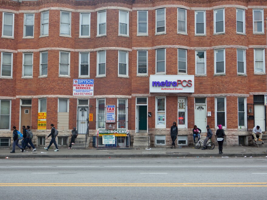 Pedestrians walk on West North Avenue in Baltimore. On Monday, the trial begins for the first of six police officers charged in Freddie Gray's death.