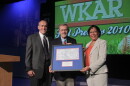 MSU Provost Kim Wilcox (left) and WKAR General Manager DeAnne Hamilton (right) presented David Hollister with a framed replica of a blueprint of Oldsmobile Park, home of the Lansing Lugnuts and known today as Cooley Law School Stadium, on Aug. 31, 2010.