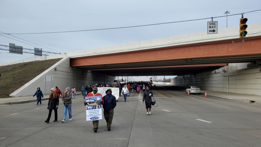 A long line of marchers walking under the Third Street Bridge in Dayton. 