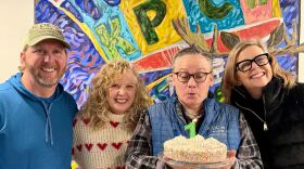 The Community Campfire's Coach Skinner, Amber Johnson, John Burdick, and Andrea Buchanan blow out the candle on the show's one-year anniversary cake