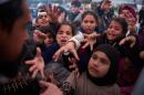Displaced families extend their hands while waiting for donated food beside the tents they use as shelters after fleeing Israeli bombardment in southern Lebanon, in Beirut, Lebanon, Thursday, April 9, 2026. (Emilio Morenatti/AP)