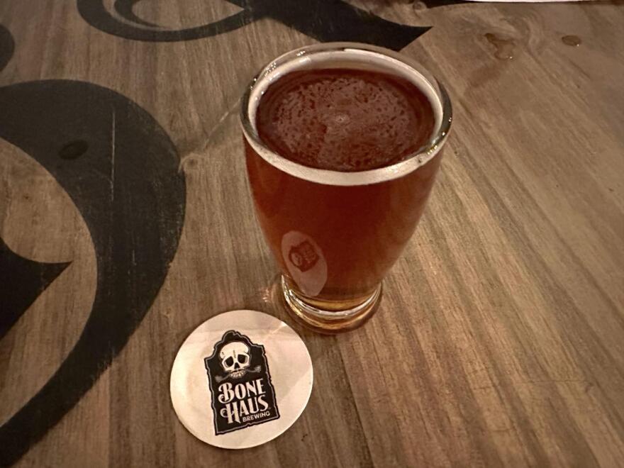 Glass of beer with coaster that reads "Bone Haus Brewing"