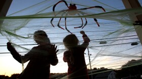 Sasha and Katia Bunner, 7 and 5, decorate for Halloween at sunset on their porch in Newton, MA. (Photo by Suzanne Kreiter/The Boston Globe via Getty Images)