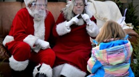 Santa and Mrs. Claus speak with a child at a garden store in Elkhart.