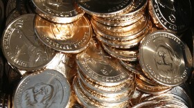 A pile of newly minted $1 coins honoring former President Thomas Jefferson are unveiled by the U.S. Mint in Washington, D.C., in 2007. In a turnaround, congressional analysts are no longer recommending a phaseout of paper dollars in favor of a dollar coin.
