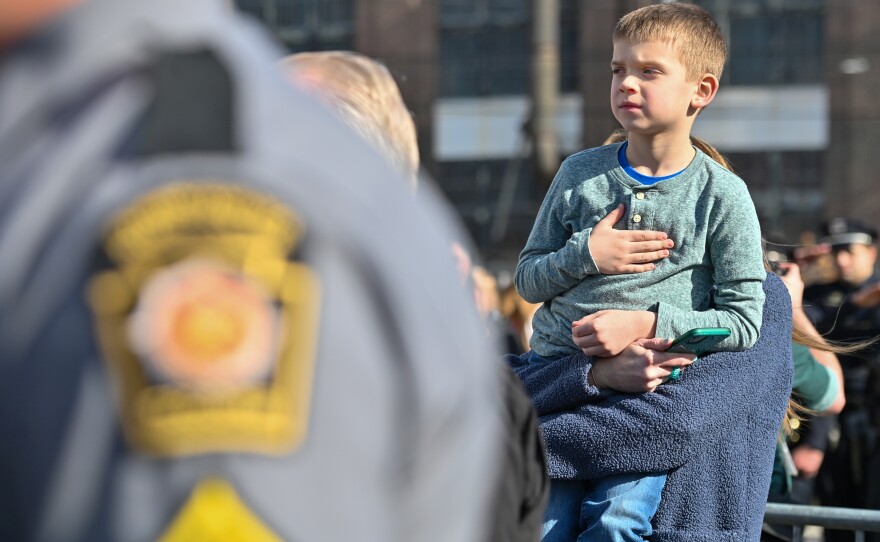 Scranton Police Detective Kyle Gilmartin's nephew is held up to see his father return to Scranton.