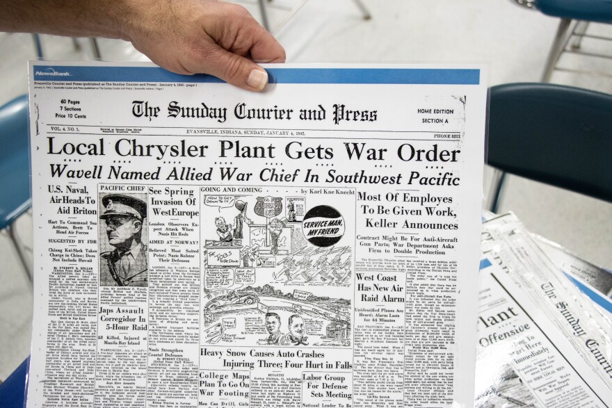 Reitz High School History Teacher Jon Carl holds one of several newspapers covering the WWII era that he shares with his classes during lessons.