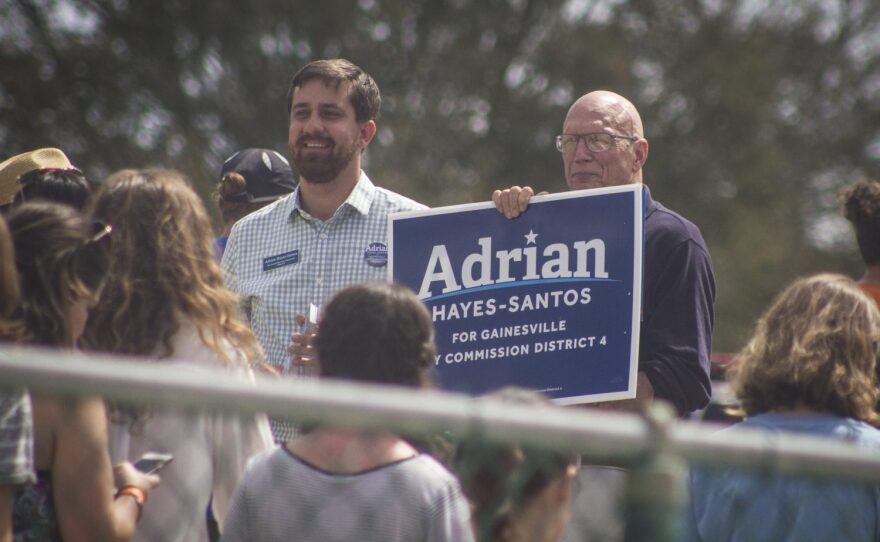 Adrian Hayes-Santos (left), a candidate for the Gainesville City Commission's District 4 seat, talks with rally attendees as they exit Thursday at the University of Florida. (Michael Stone/WUFT News)