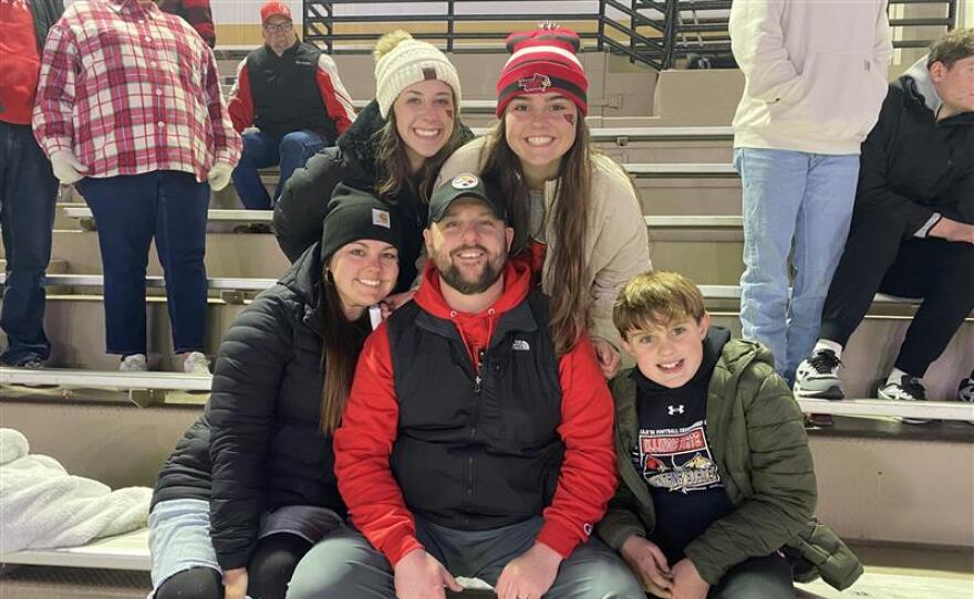 A family poses for a photo at a football game