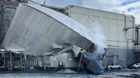 This photo provided by the City of Longview, Wash., shows structural damage to the Nippon Dynawave Packaging Co., after a tank containing hazardous liquid imploded, on Tuesday, May 26, 2026 in Longview, Wash. (City of Longview via AP)