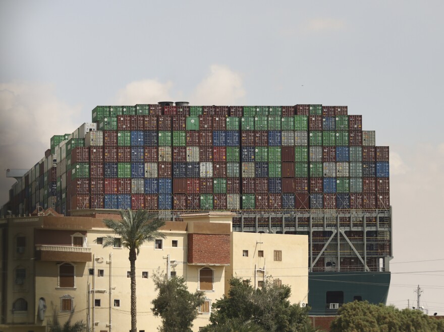 The Panama-flagged Ever Given is seen wedged across the Suez Canal on Friday. Tugboats, dredgers and even land-based earth-moving equipment have been pressed into service to try to free the 1,300-foot container ship.