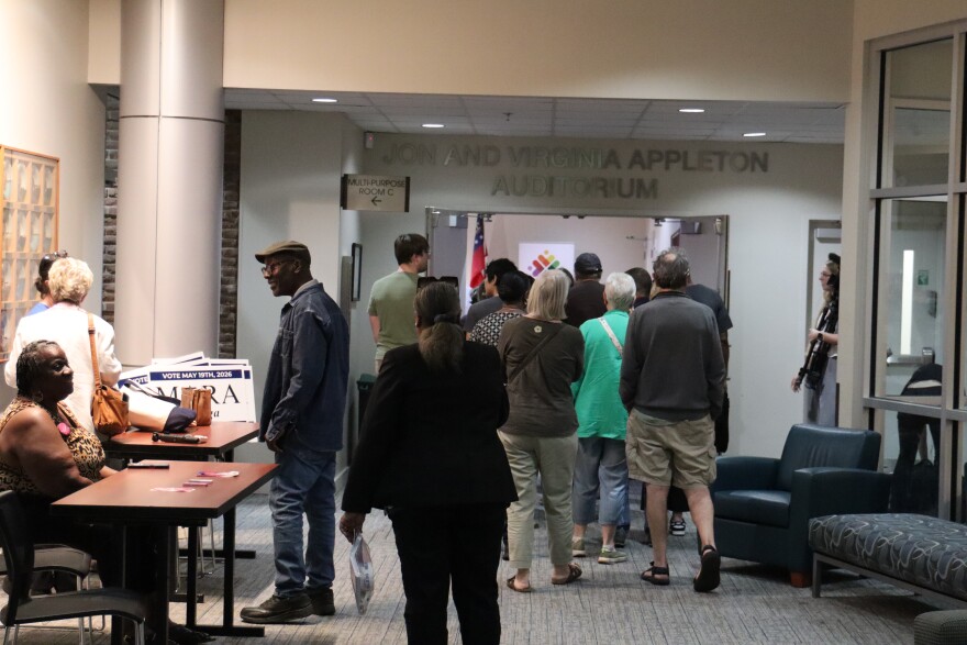 People gather outside an auditorium before an event.