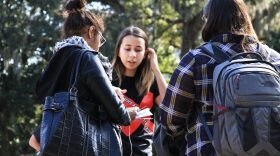 Ana Oliveira-Beuses, center, informs students about the University of Florida's Gators Against Human Trafficking at the Plaza of the Americas Monday. Oliveira-Beuses, historian, said the biggest obstacle to combating human trafficking is a lack of community education on the topic. (Giuseppe Sabella/WUFT News)