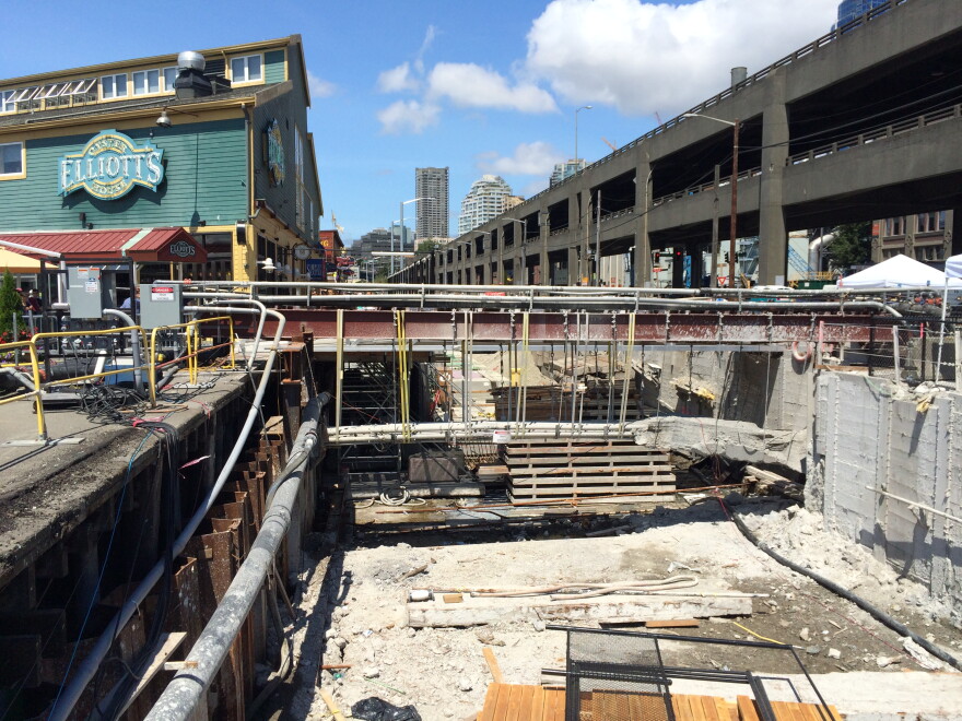 Crews have yet to finish stabilizing the soil behind the seawall. That work is going on in front of Colman Dock, nearby. But work has stopped in front of the shops and restaurants for tourist season. 