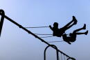 Children play on swings during National Night Out, Tuesday, August 1, 2023, in Salisbury, Maryland. (Julia Nikhinson/AP)