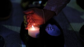 A woman lights a candle inside a pair of shoes that were among hundreds displayed in memory of those killed by Hurricane Maria in front of the Puerto Rican Capitol, in San Juan in June.