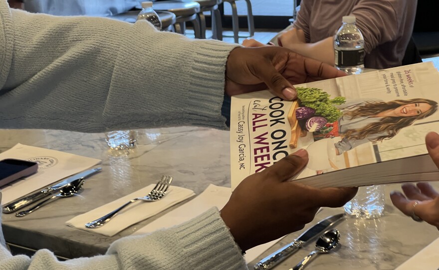 Students pass around Cassy Garcia's Cook Once, Eat All Week cookbook 