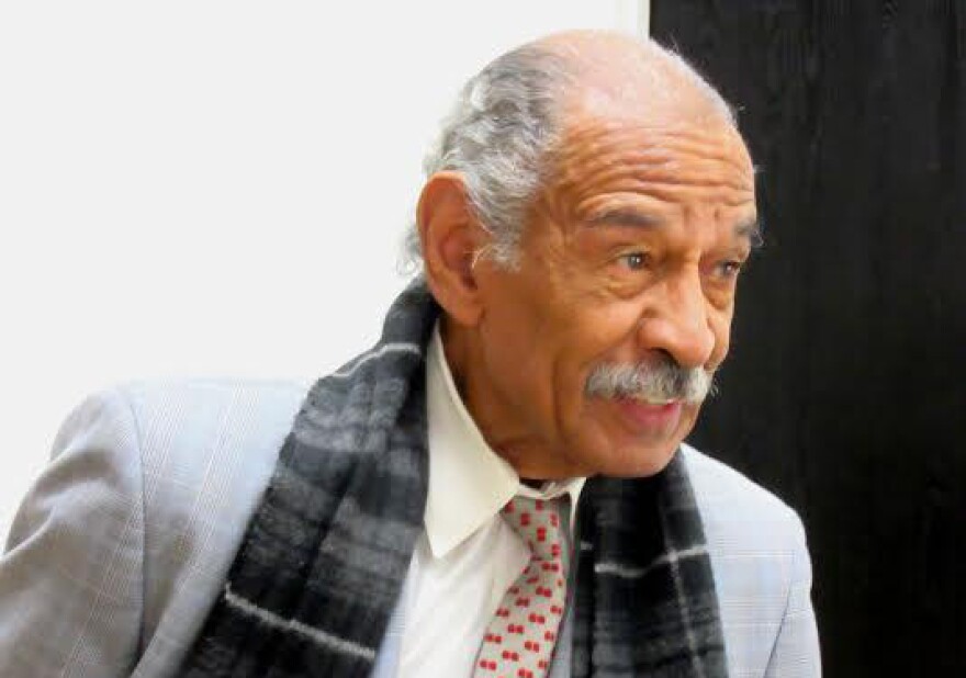 Congressman John Conyers in a light gray jacket and scarf 