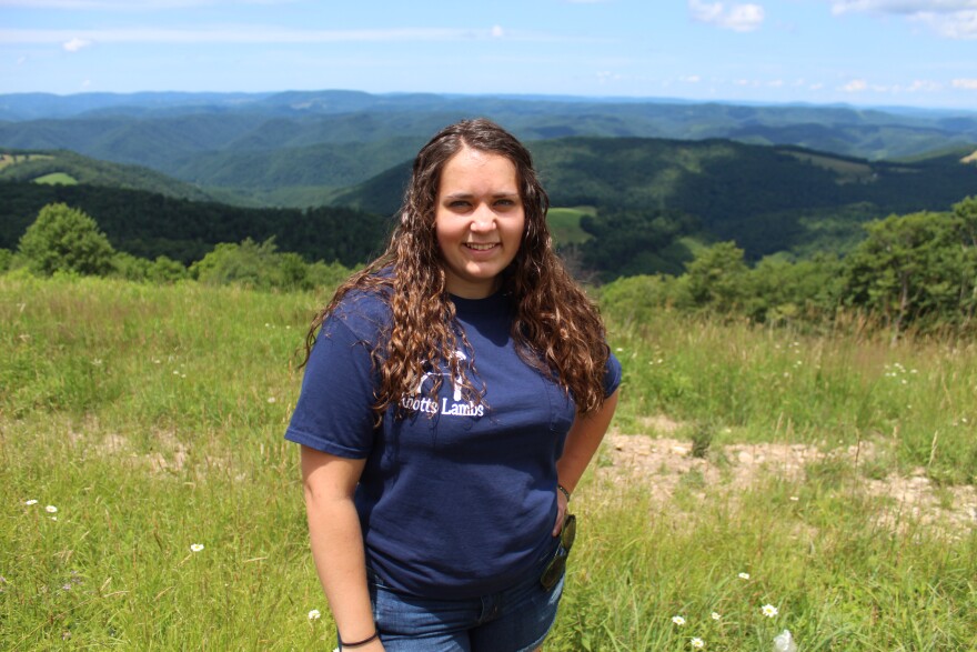 Lindsay Knotts standing on a hilltop above her family farm in Tucker County. The Knotts have been farming in Tucker County for several generations. 