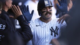 New York Yankees' Austin Wells celebrates his solo home run in the dugout during the first inning of an opening-day baseball game against the Milwaukee Brewers at Yankee Stadium, Thursday, March 27, 2025, in New York. (AP Photo/Seth Wenig)
