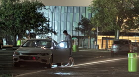 A person uses a flashlight near a vehicle on Michigan State University’s East Lansing campus during a widespread power outage Saturday night, Sept. 19, 2026.