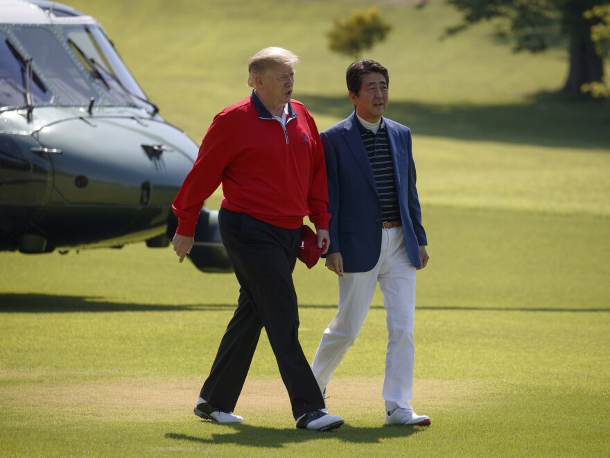 President Trump walks with Japanese Prime Minister Shinzo Abe before playing a round of golf on Sunday in Shiba, Japan.