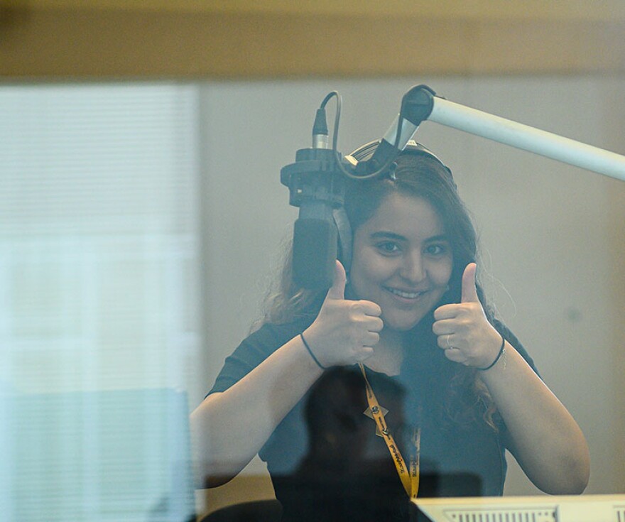 Producer giving thumbs up, behind glass