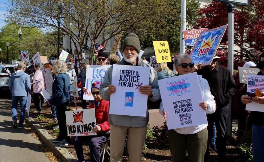 Two protestors on the corner of 3rd and Princess Street holding up signs during the No Kings protest.