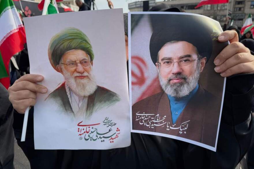 A woman holds posters of Ayatollah Mojtaba Khamenei, right, the successor to his late father, Ayatollah Ali Khamenei, left, as supreme leader, during a rally supporting him in Tehran, Iran, Monday, March 9, 2026. (Vahid Salemi/AP)