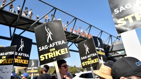 Picketers carry signs on the picket line outside Universal Studios on Friday, Aug. 4, 2023, in Universal City, Calif. The actors strike comes more than two months after screenwriters began striking in their bid to get better pay and working condition
