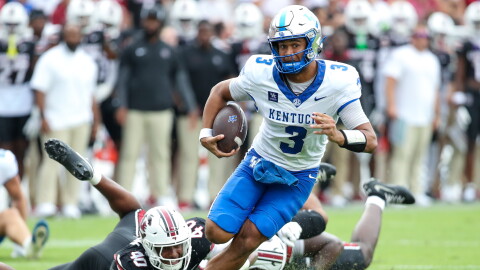 Kentucky quarterback Kenny Minchey (3) runs for a first down past South Carolina defensive lineman Anthony Addison (40) during the first half of an NCAA college football game Saturday, Oct. 3, 2026, in Columbia, S.C. (AP Photo/Artie Walker Jr.)